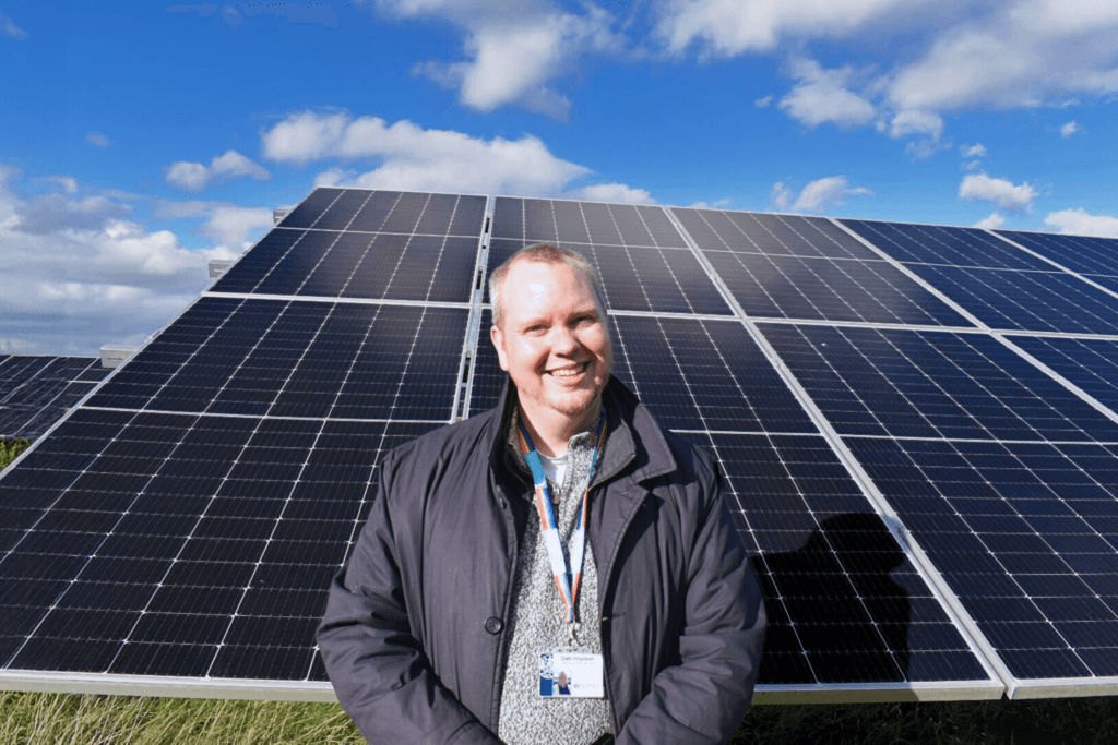 A Low Carbon Hub investor in front of solar panels.